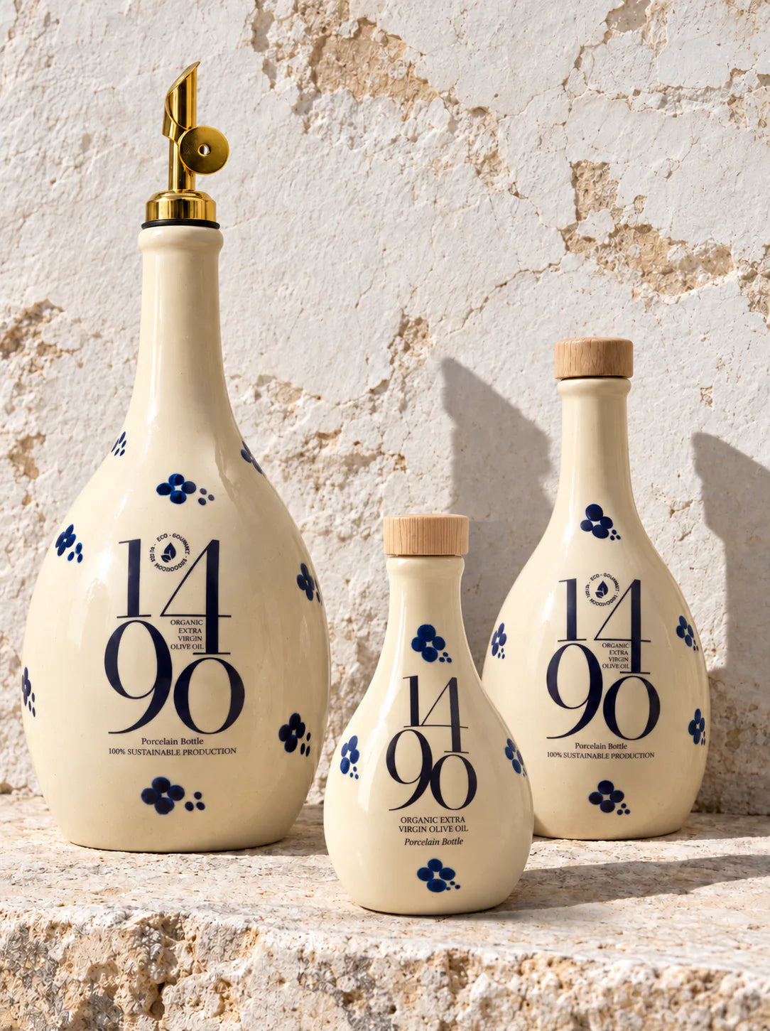 Las tres medidas de la frasca Santa Maria Galera -500, 250 y 100 ml- sobre piedra al sol, con el tapon dosificador de oro